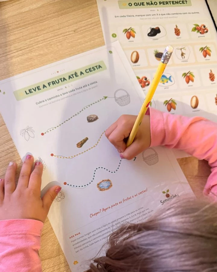 Criança fazendo a atividade Leve a fruta até a cesta